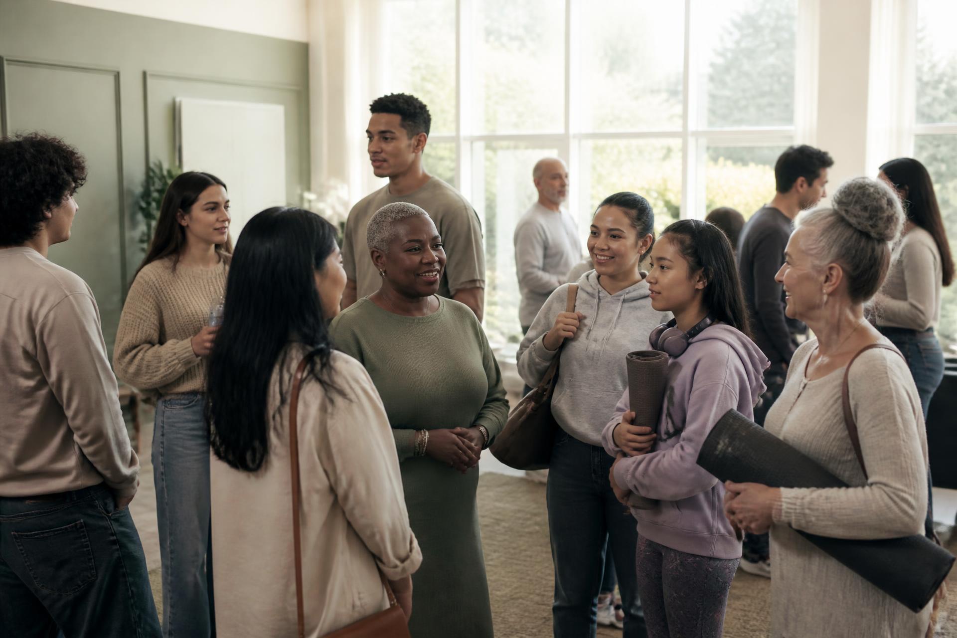 People of different backgrounds and ages talking together in warm afternoon light
